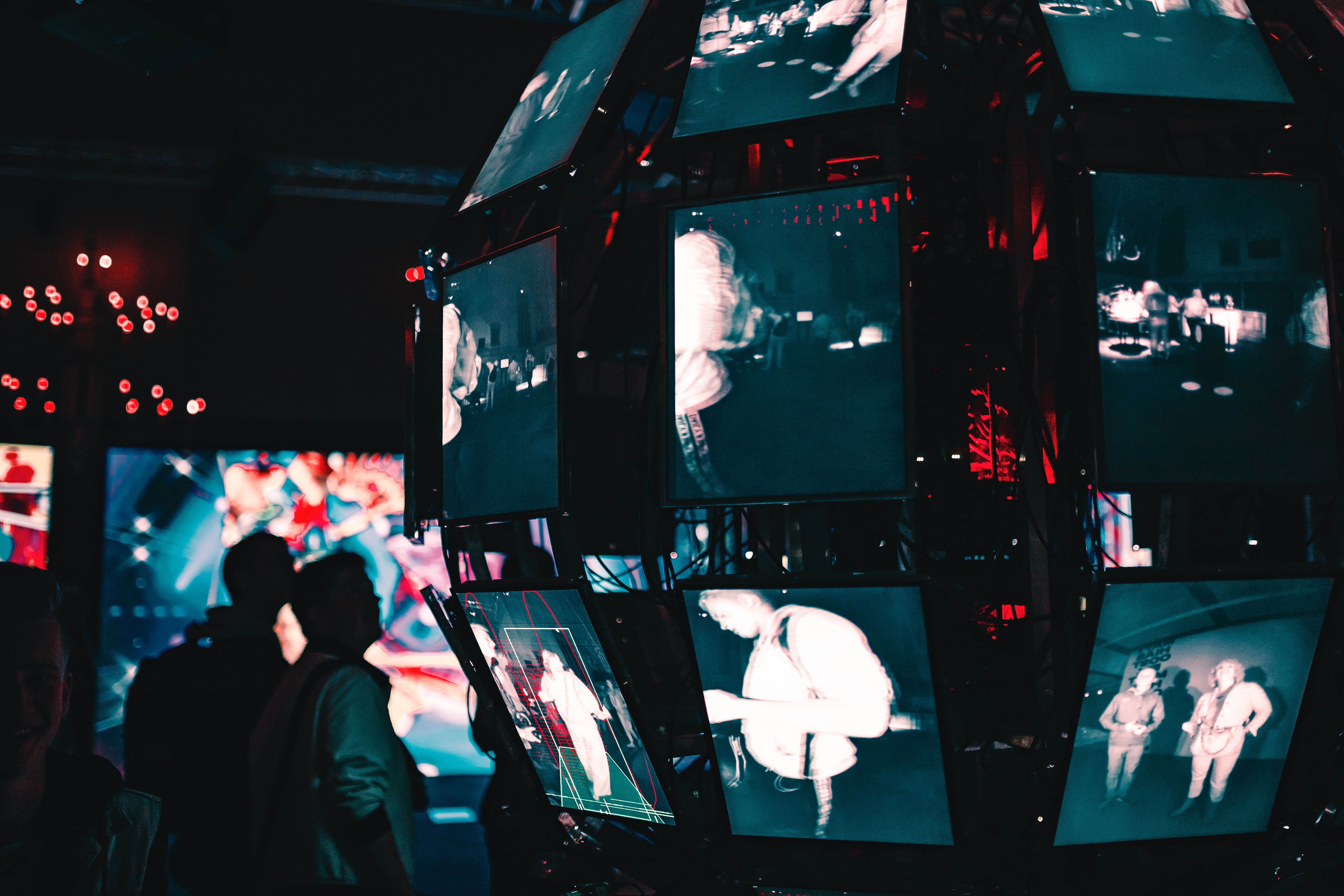 A sphere made of television screens displays different images of people.